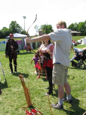 2(Sun) Pirate Fest - Archery - Ben
Ben lines up a good shot despite a small pirate biting down on the end of his arrow.
Keywords: gathering10